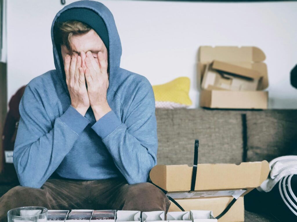 Person sitting on a couch with their face in their hands, showing signs of stress and exhaustion — a visual representation of medical school burnout.